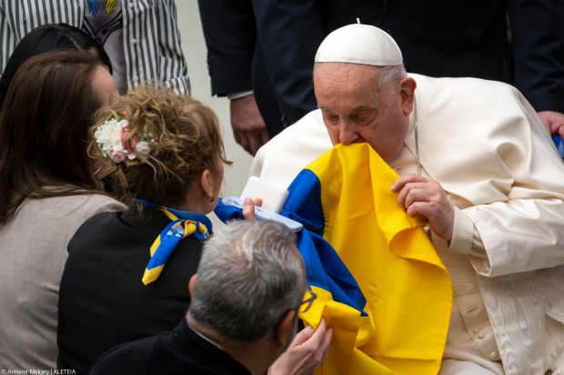 Pope Francis kisses the Ukrainian flag