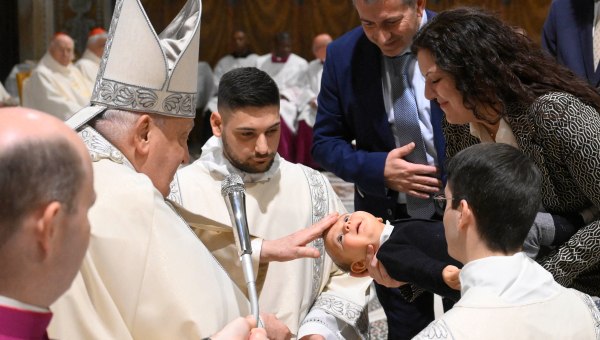 Pope Francis (L) carrying baptisms of infants as celebrates the mass for the Feast of the Baptism of the Lord in the Sistine Chapel, at the Vatican.