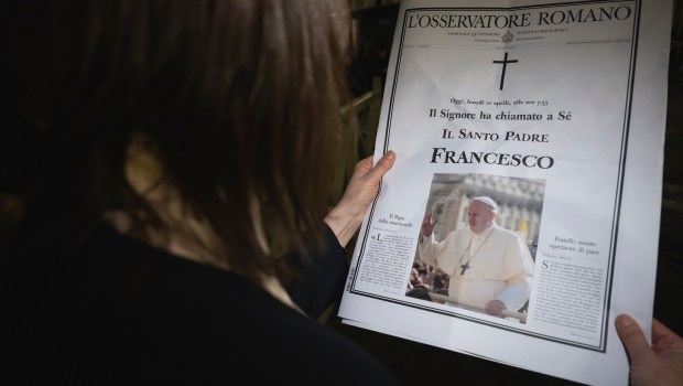 A woman holds a special edition of the Vatican newspaper L'Osservatore Romano announcing the death of Pope Francis, in St. Peter's Square