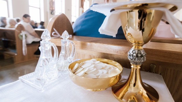 Przygotowanie darów. Patena pełna komunikantów, ampułki i kielich